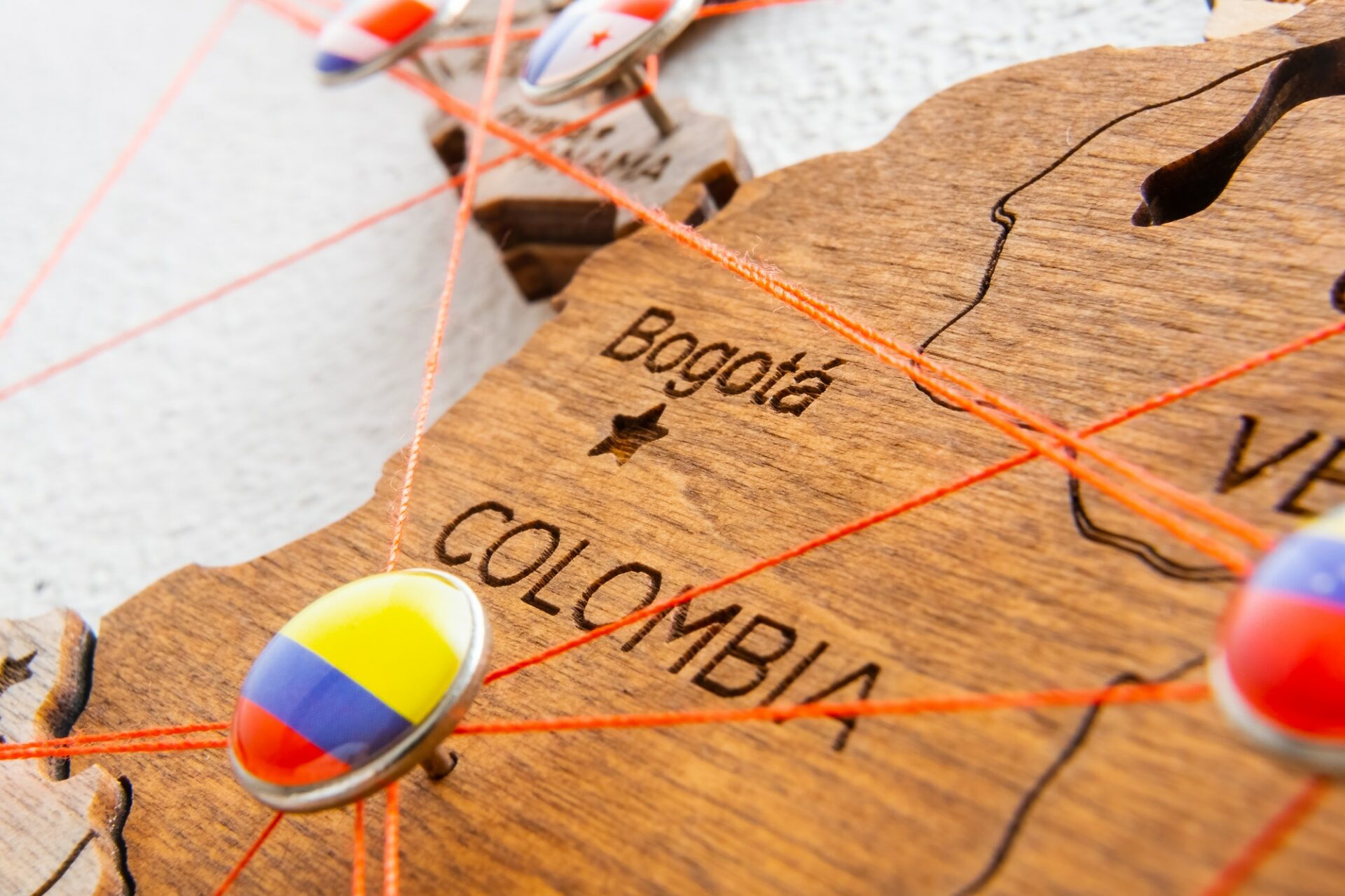 Colombia flag pins and red thread for traveling and planning trip.